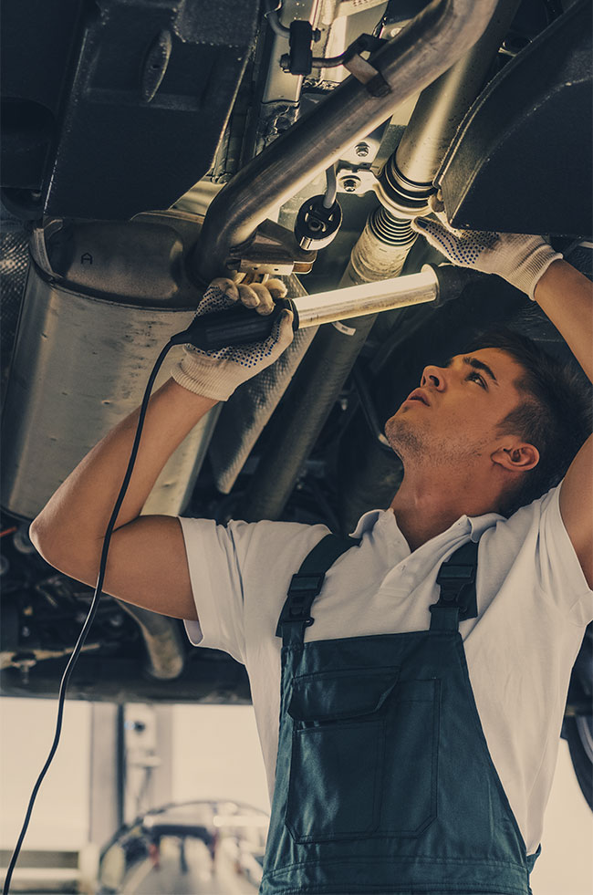 Mechanic looking under a vehicle - MOT and Servicing Leighton Buzzard.